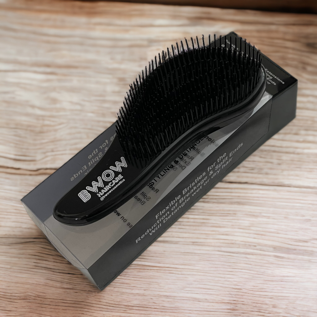 black hair brush on a box of packaging on a wooden background