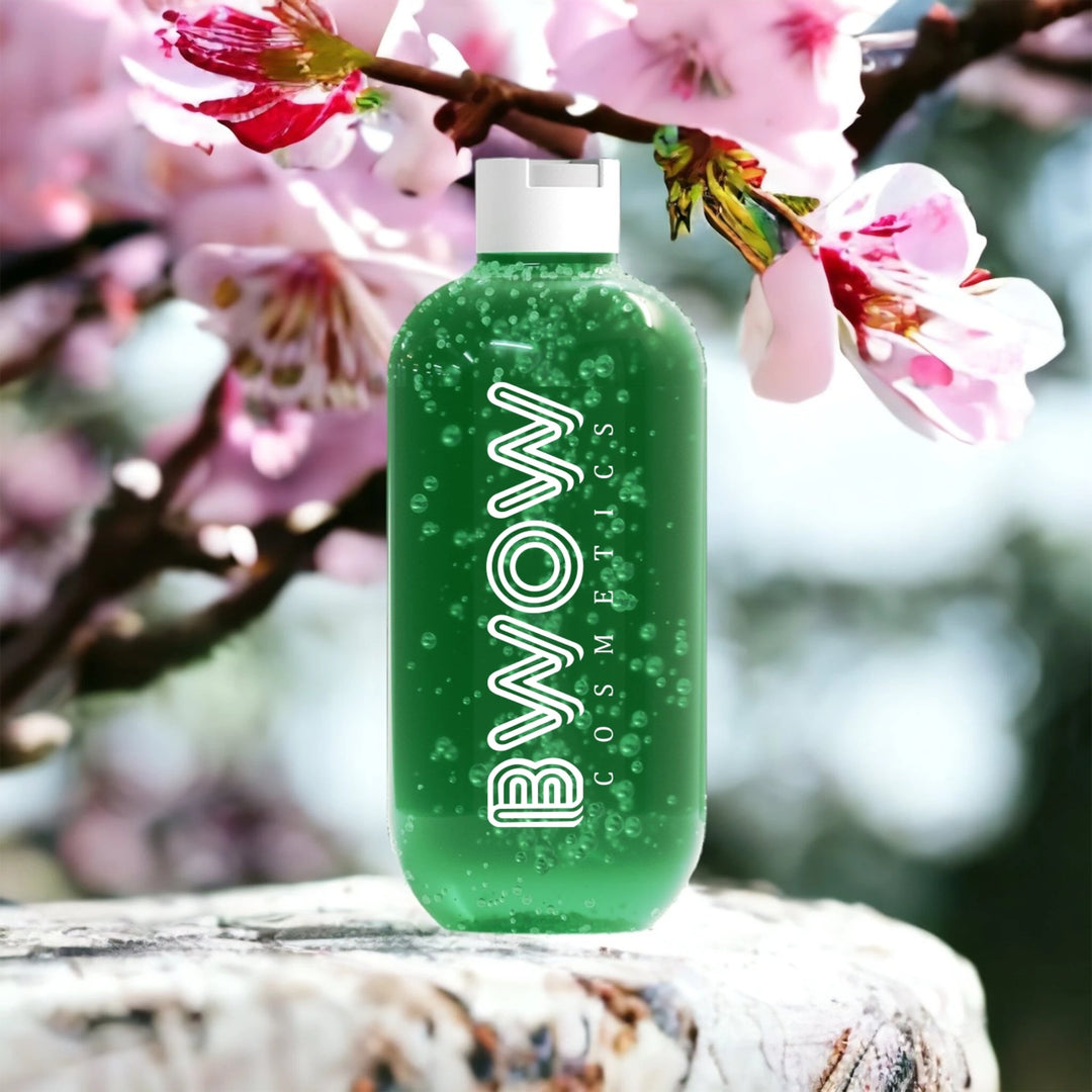 aloe vera gel bottle surrounded by pink flowers on a stone