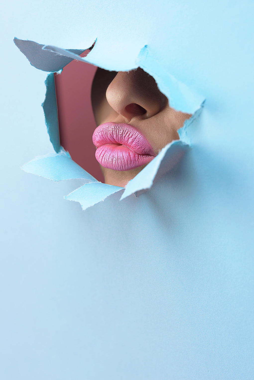 pink lipstick lips through blue paper